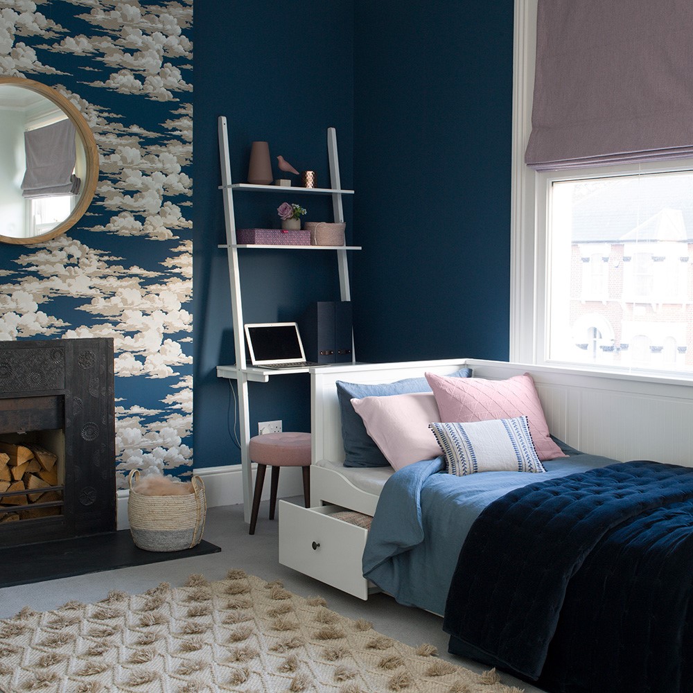 Slaapkamer met donkerblauwe muur en wolkenbehang